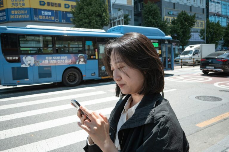 Person using a smartphone on a Seoul street, illustrating public WiFi use